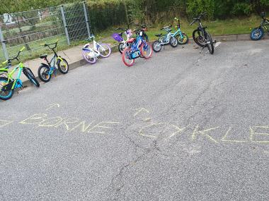 Børnecykler på asfalteret plads